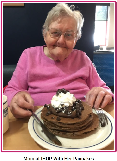 Mom at IHOP with her chocolate pancakes, whipped cream, and chocolate sauce.